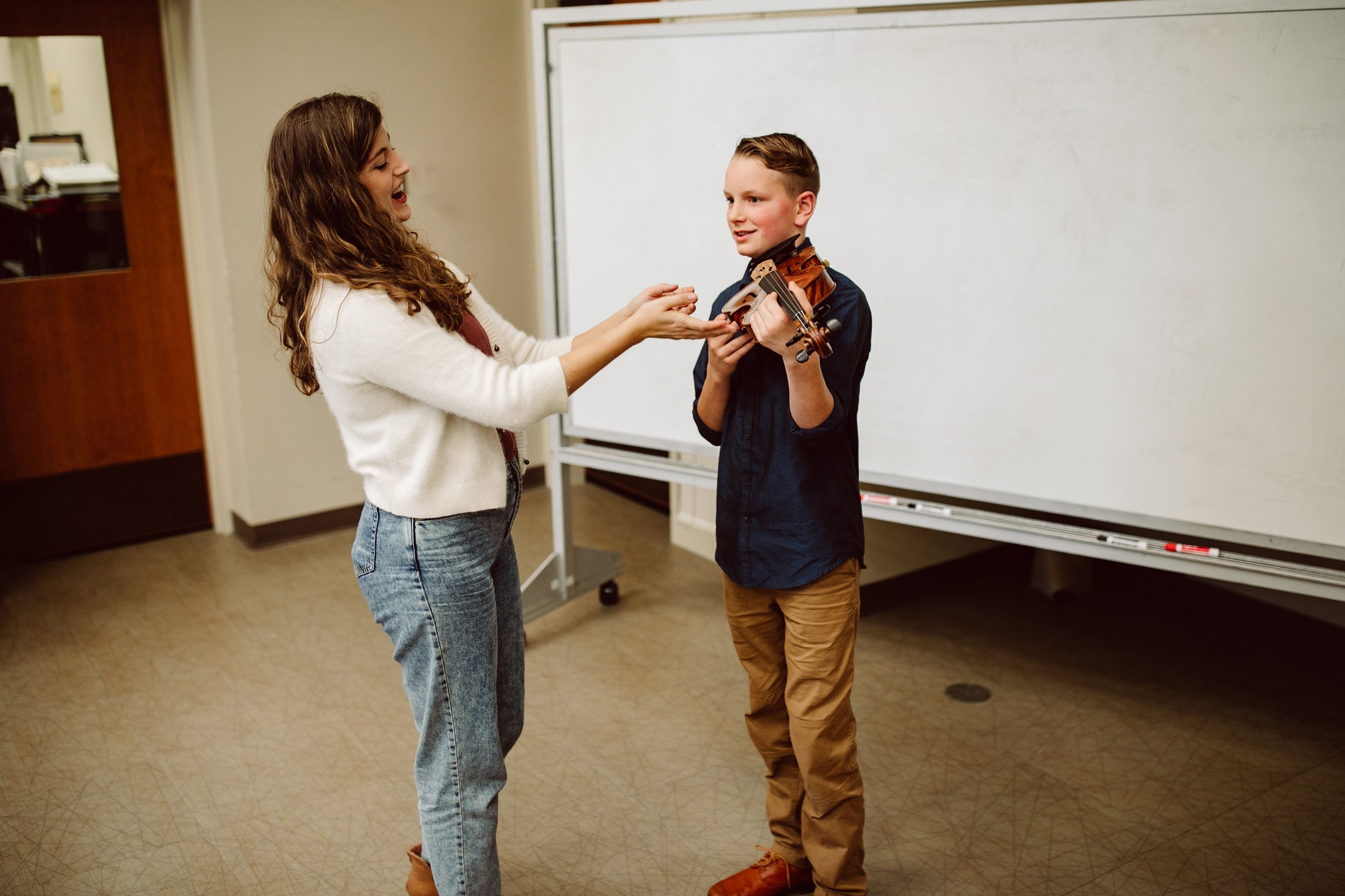 Violin teacher teaching a student in a lesson
